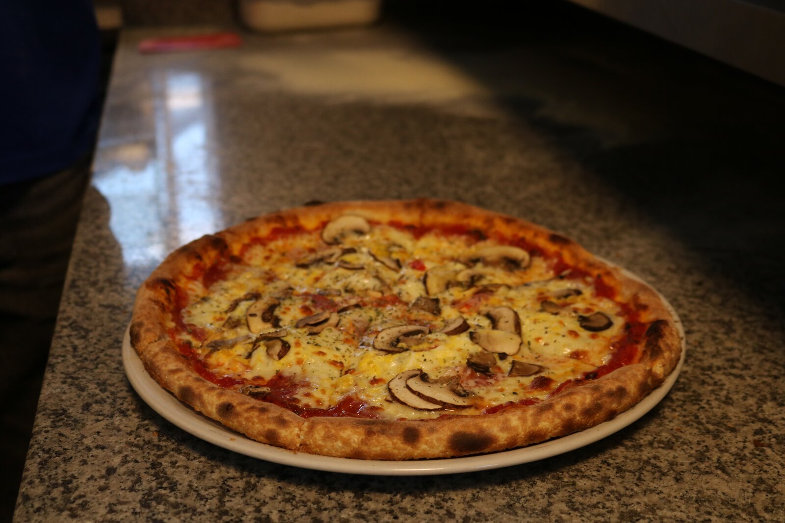 Frisch belegte Pizza aus dem Steinofen bei Mig Mig