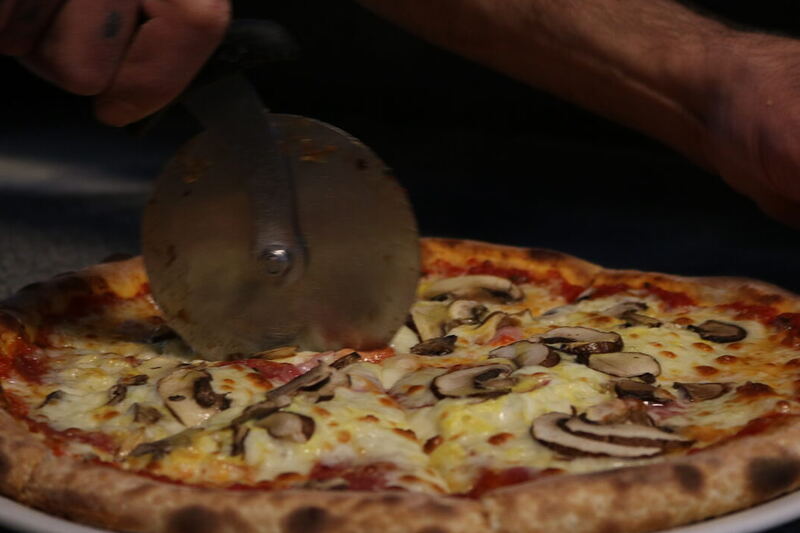 Pizza wird frisch geschnitten